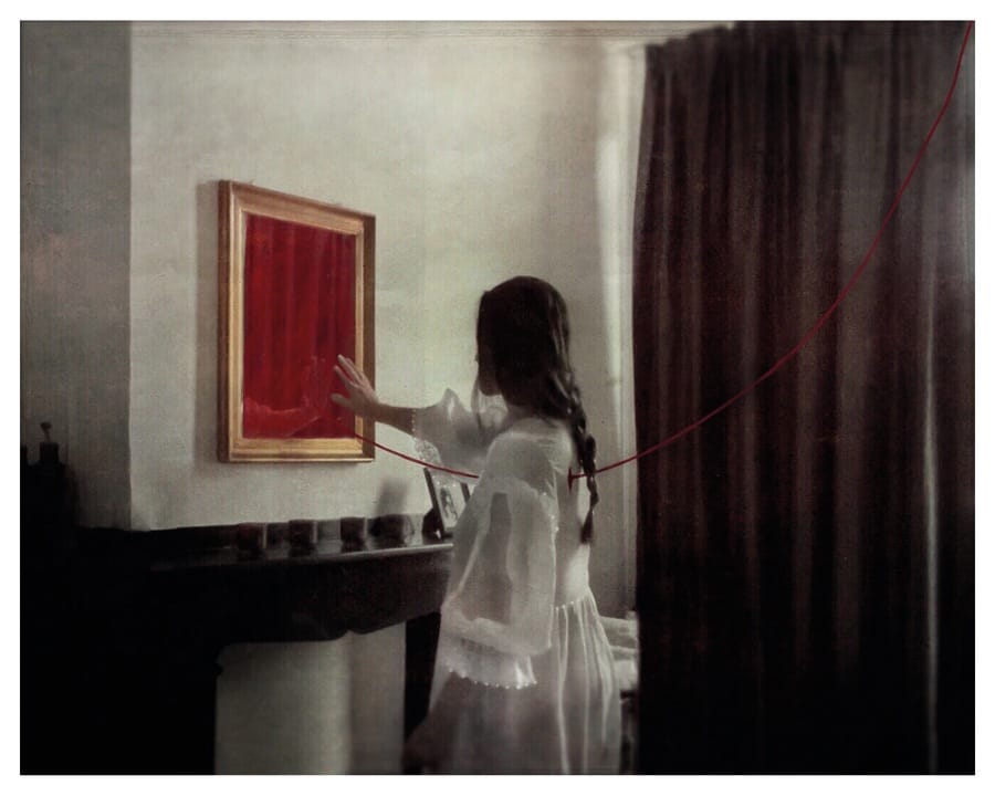 Ana Priscila Rodriguez photograph of woman in a white nightgown reaching out to a red painting