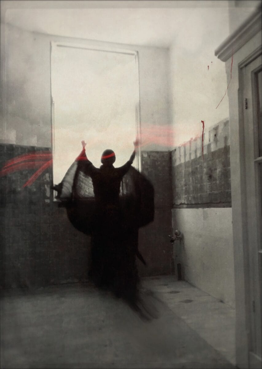 Ana Priscila Rodriguez photograph of woman in dark clothes next to a window with her arms raised