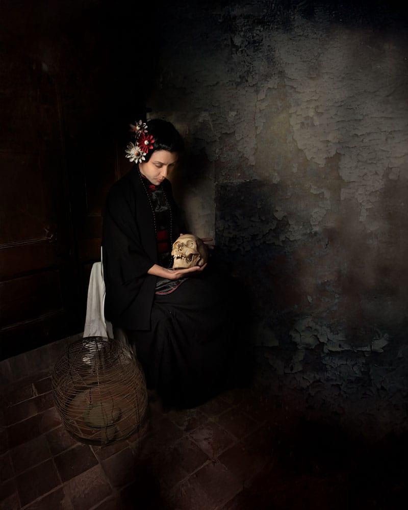 Diego Orlando painting of woman holding a skull