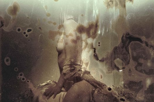 Abstract sepia photograph of a woman with her head turned to the camera by Jeremy Mann